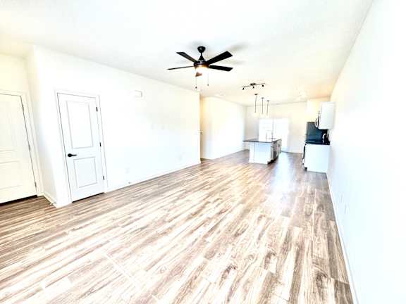 A room with a ceiling fan and wooden flooring.at Concord Crossing, Lafayette, IN
