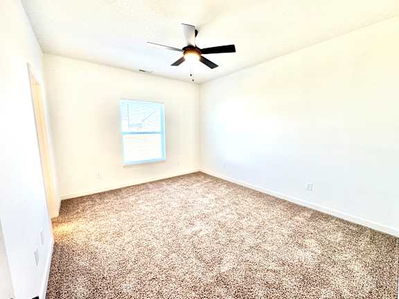 A room with a ceiling fan and carpeted floor.at Concord Crossing, Indiana, 47909