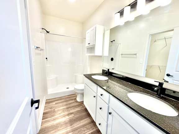 A white bathroom with a sink, mirror, and toilet.at Concord Crossing, Lafayette