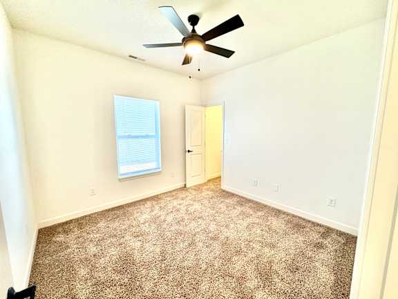 A room with a ceiling fan and carpeted floor.at Concord Crossing, Indiana