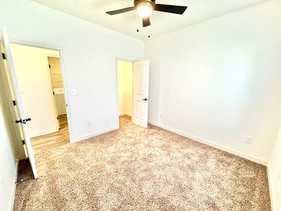 A room with a carpeted floor and a ceiling fan.at Concord Crossing, Lafayette, 47909