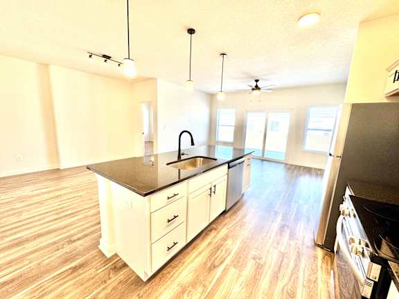 A kitchen with a black countertop and white cabinets.at Concord Crossing, Indiana
