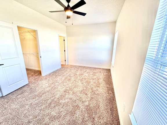 A room with a ceiling fan and carpeted floor.at Concord Crossing, Lafayette Indiana