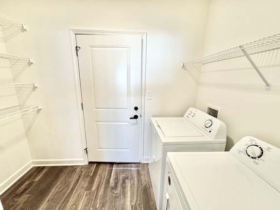 A white door is in a laundry room with a washer and dryer.at Concord Crossing, Lafayette, 47909