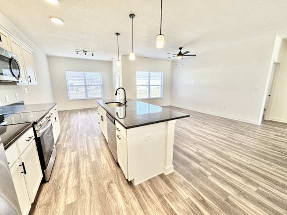 A kitchen with white cabinets and a black countertop.at Concord Crossing, Lafayette Indiana