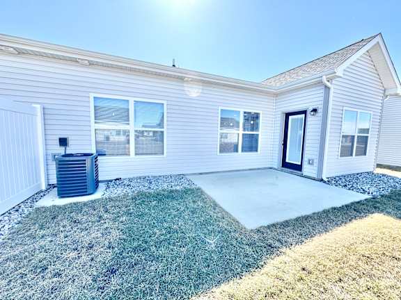 A house with a grey siding and a black door is shown.at Concord Crossing, Lafayette, 47909