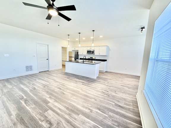 A spacious kitchen with a fan and wooden flooring.at Concord Crossing, Lafayette
