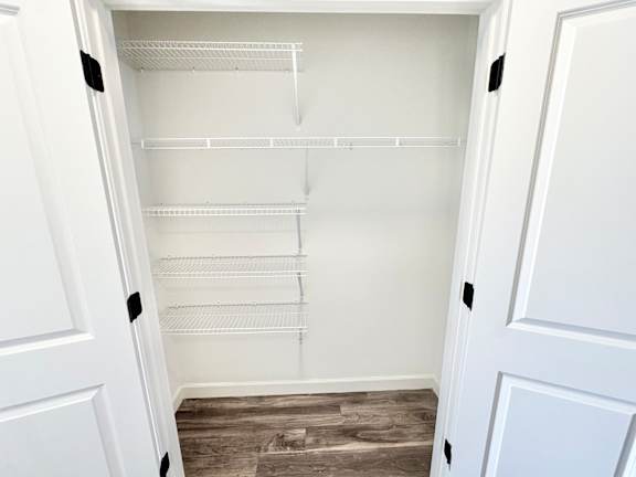 A white empty pantry with a white door and a white fridge.at Concord Crossing, Indiana