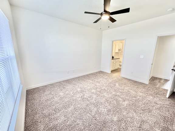 A room with a ceiling fan and carpeted floor.at Concord Crossing, Lafayette