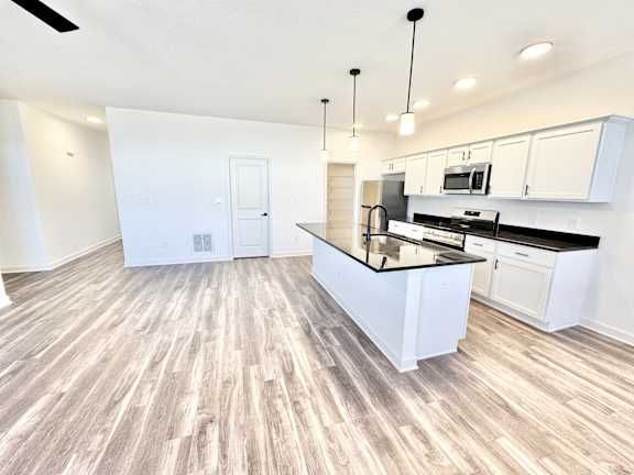 A kitchen with a white island and black countertops.at Concord Crossing, Lafayette