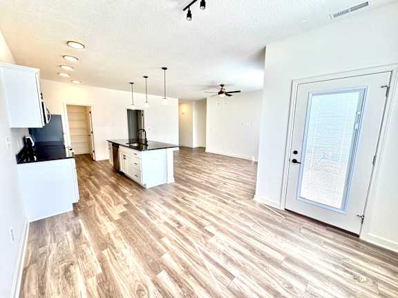 A kitchen with a black countertop and white cabinets.at Concord Crossing, Indiana, 47909