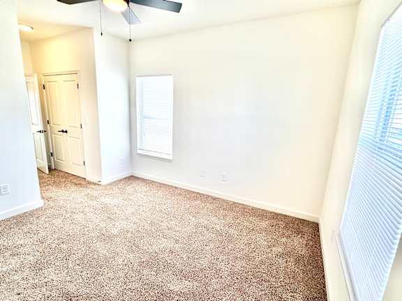A room with a carpeted floor and a ceiling fan.at Concord Crossing, Indiana