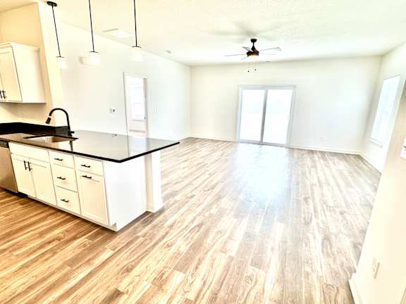 A kitchen with a black countertop and white cabinets.at Concord Crossing, Indiana, 47909