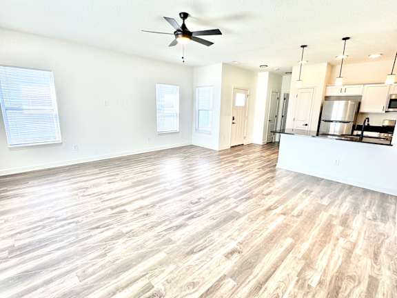 A spacious room with a ceiling fan and wooden flooring.at Concord Crossing, Lafayette Indiana