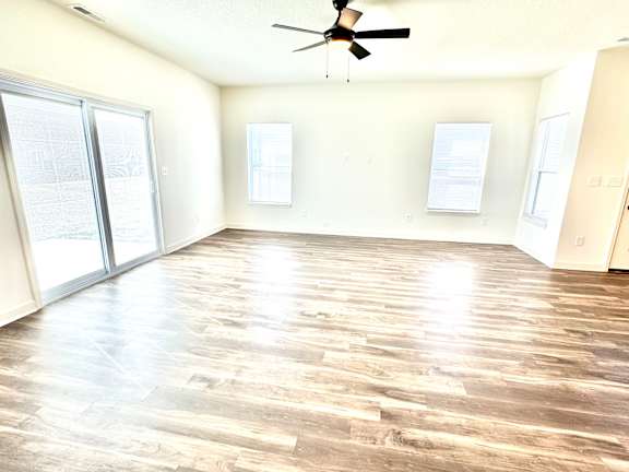 A room with a ceiling fan and wood flooring.at Concord Crossing, Lafayette, IN 47909
