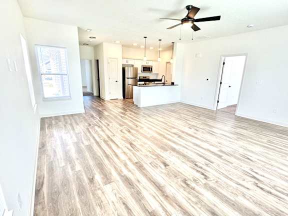 A spacious living room with a kitchen in the background.at Concord Crossing, Lafayette, 47909