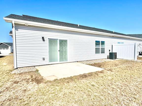 A single-story house with a grey exterior and a green door.at Concord Crossing, Indiana, 47909