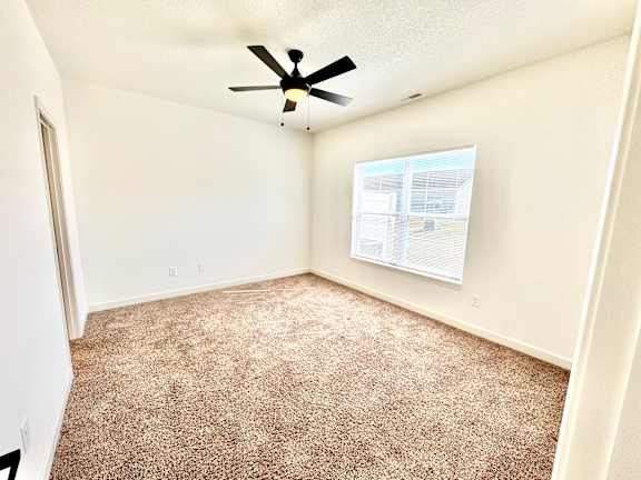 A room with a ceiling fan and carpeted floor.at Concord Crossing, Lafayette Indiana