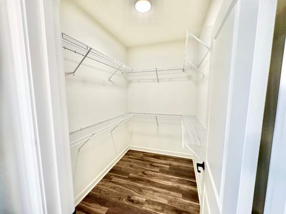A walk-in closet with white walls and wooden floors.at Concord Crossing, Lafayette