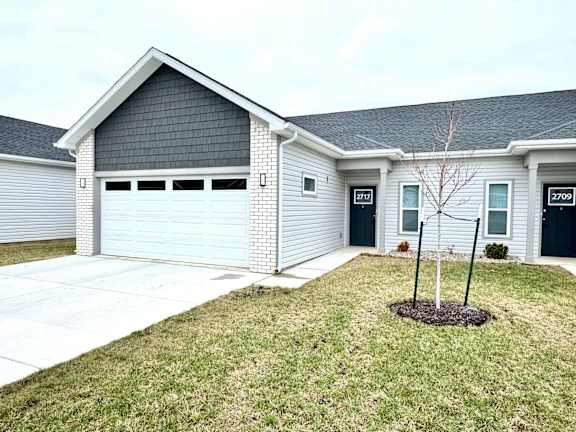 A two-story house with a garage and a small tree in front.at Concord Crossing, Indiana