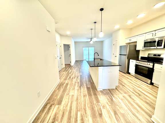 A kitchen with a black countertop and stainless steel appliances.at Concord Crossing, Lafayette Indiana