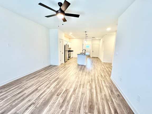 A room with a ceiling fan and wooden flooring.at Concord Crossing, Indiana