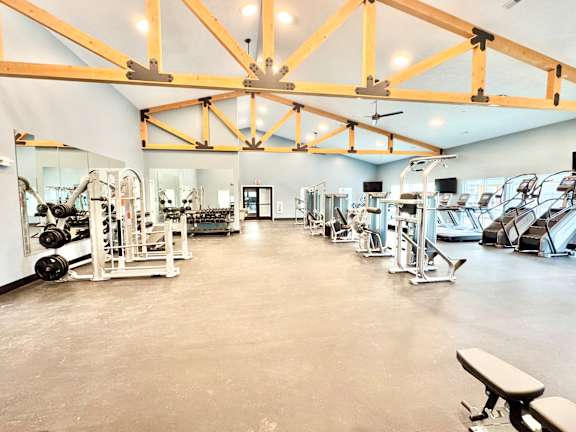A gym with a variety of equipment and a large mirror on the wall.at Concord Crossing, Indiana, 47909