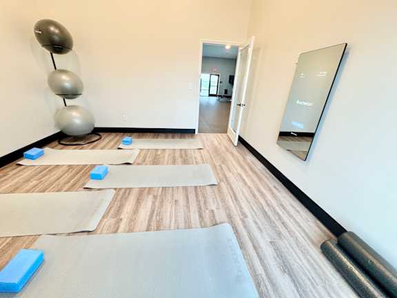 A yoga studio with a mirror and yoga mats on the floor.at Concord Crossing, Lafayette Indiana