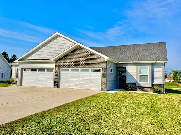 A two-car garage with a grey roof and a white wall.