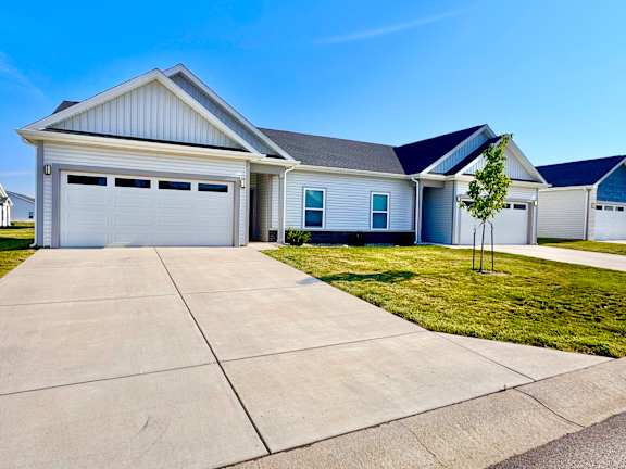 A two-story house with a garage and a driveway.
