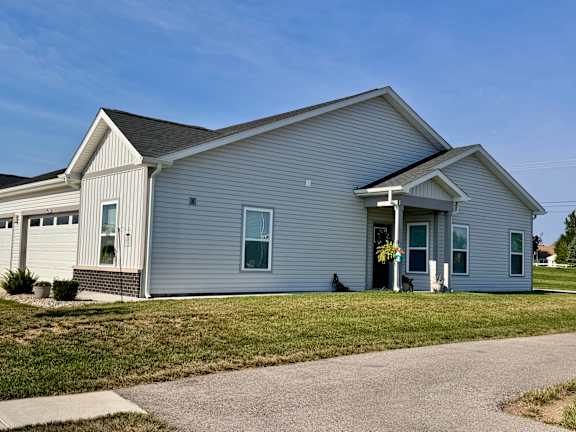 A house with a grey siding and a white trim.