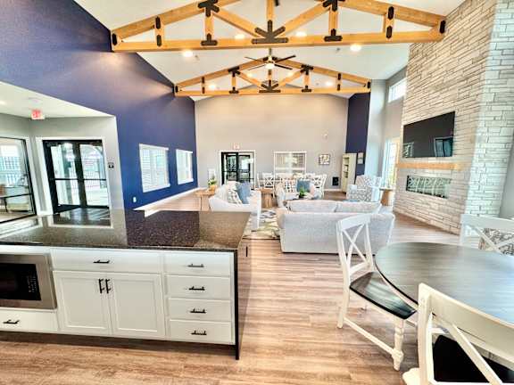 A kitchen with a white counter and a white chair.