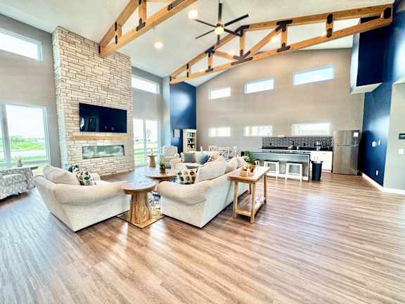 A living room with a stone fireplace and a large couch.