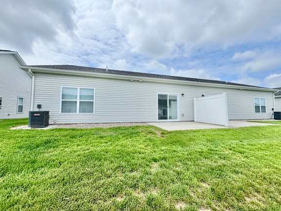 A house with a grey siding and a white garage door.