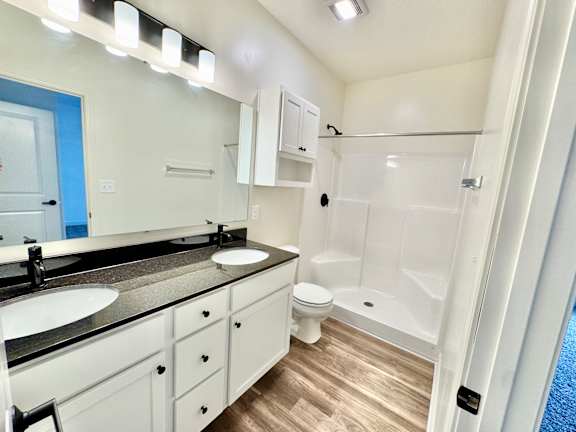 A bathroom with a sink, toilet, and shower.