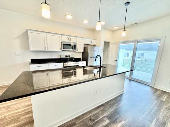 A kitchen with black countertops and white cabinets.
