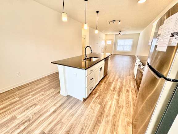 A kitchen with a black countertop and white cabinets.