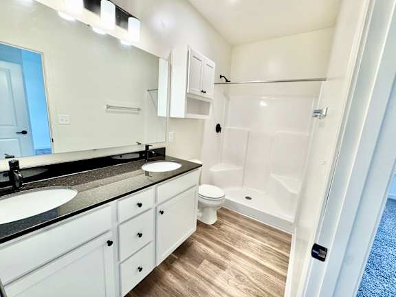 A bathroom with a sink, toilet, and shower.