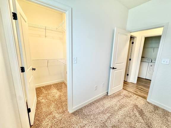 A white door is open to a room with a carpeted floor.
