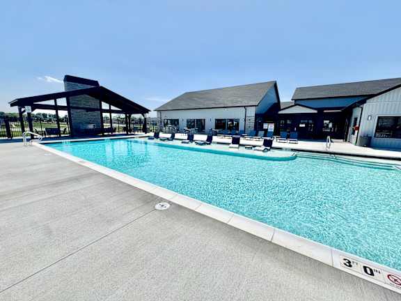 A large outdoor swimming pool with a building in the background.