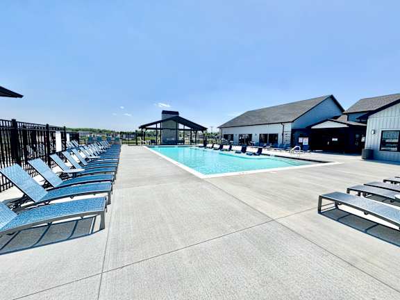 A pool area with sun loungers and a pavilion.