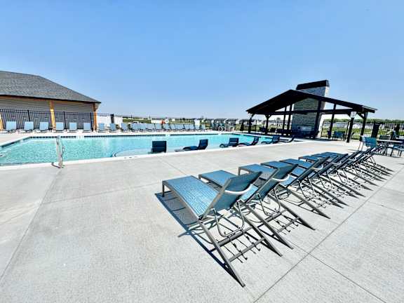 A poolside area with sun loungers and a pavilion.
