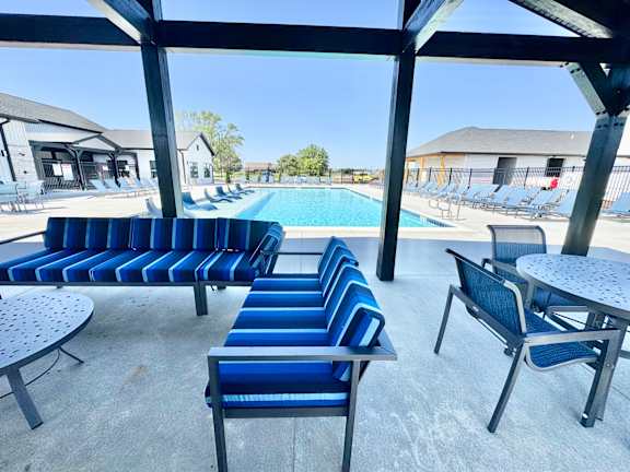 A poolside area with blue and white striped seating.