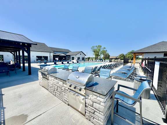 A row of outdoor grills are lined up on a patio.