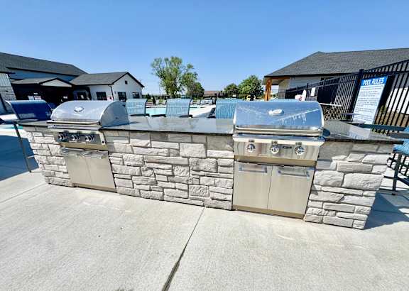A stone wall with two ovens on top of it.