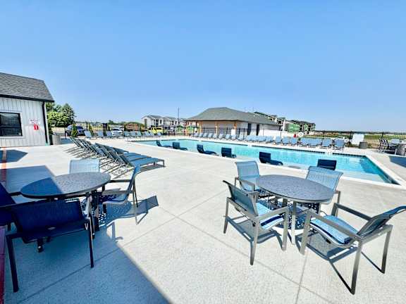 A poolside area with tables and chairs.
