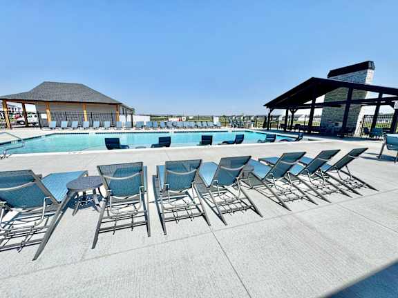 A poolside area with chairs and a pavilion.