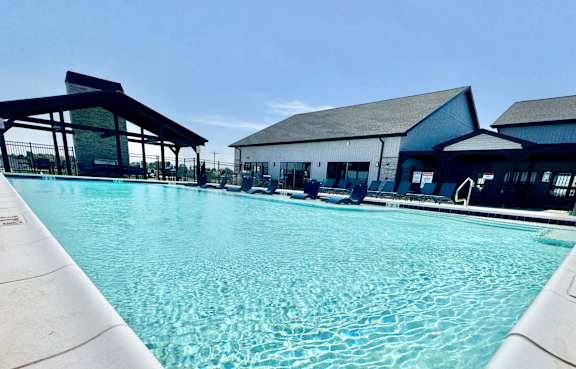 A large swimming pool with a building in the background.