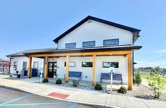 A modern building with a wooden exterior and a covered entrance.