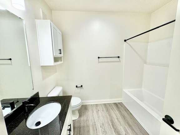 A bathroom with a sink, toilet, and bathtub.